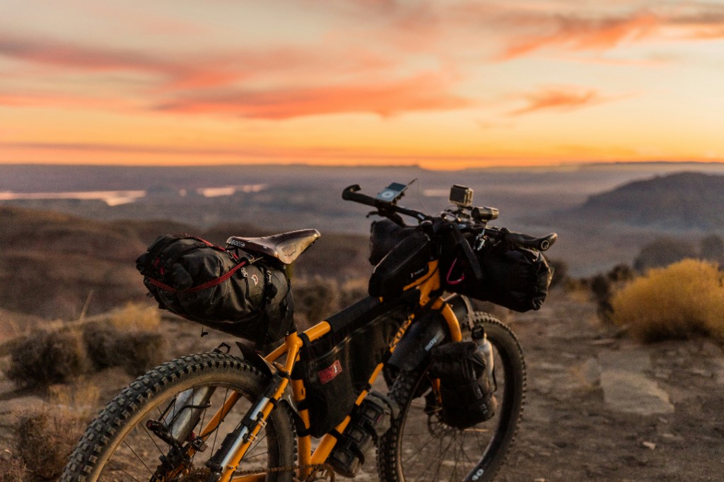 Kolo z bikepacking torbami ob sončnem zahodu