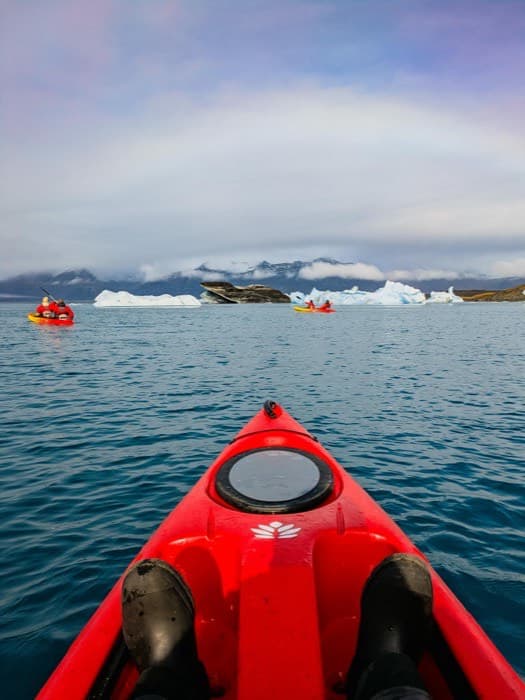 Kayak on a calm sea with icebergs